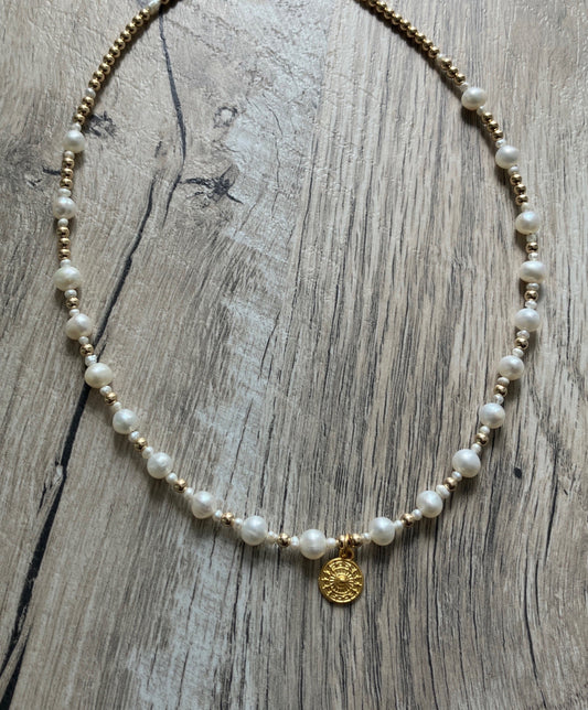 Pearl and gold clasp necklace with a gold circle sun like pendant