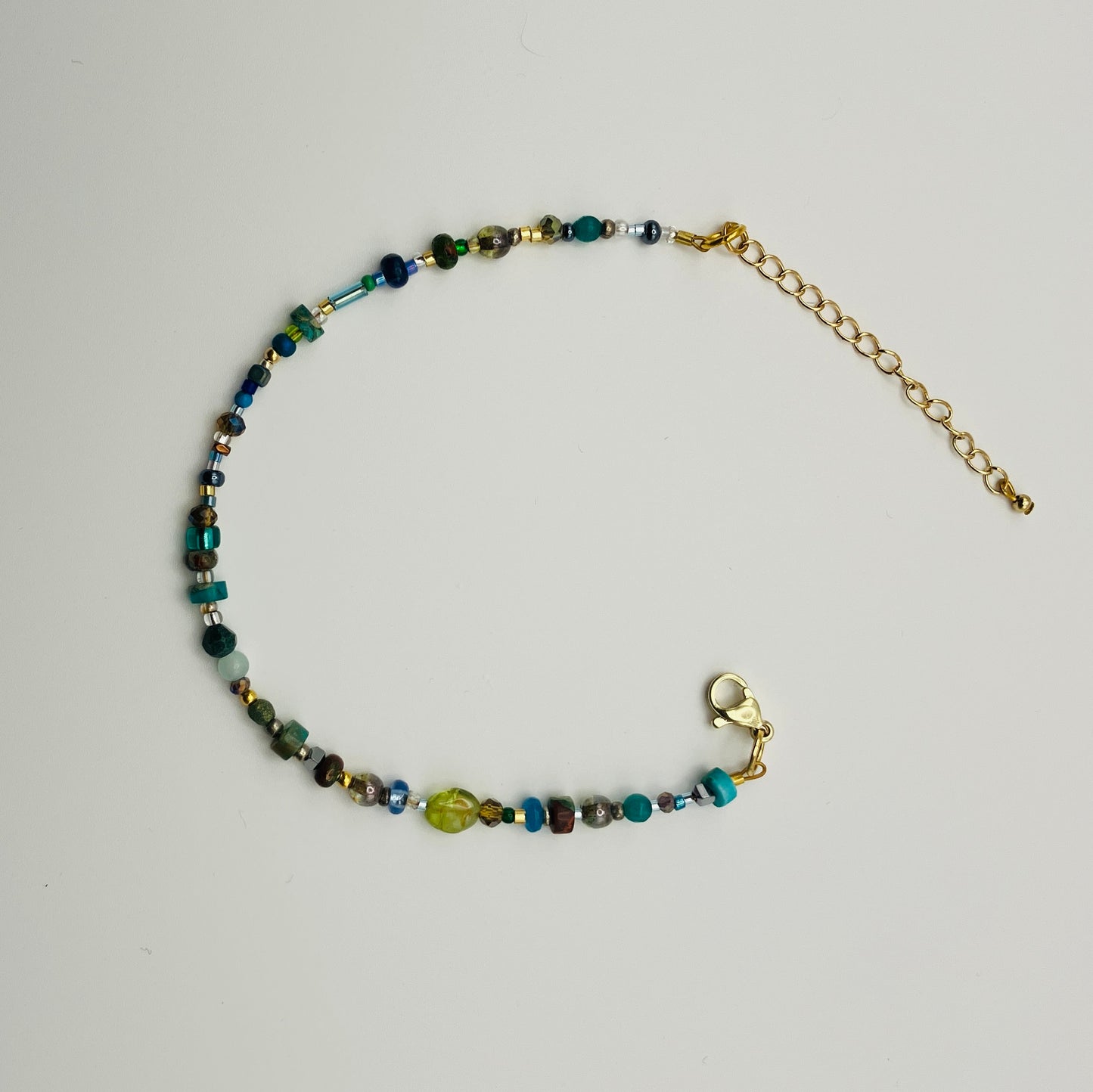 Green and gold beaded bracelet with lobster clasp